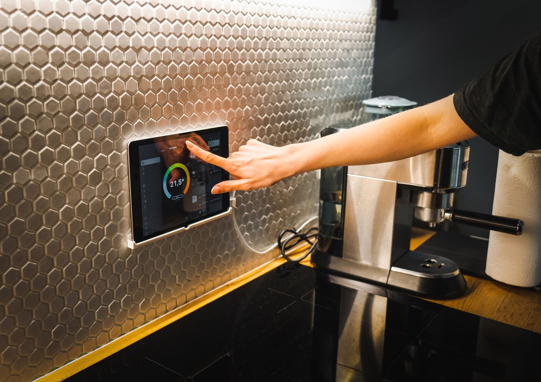 Hand touching a wall-mounted smart-home control panel