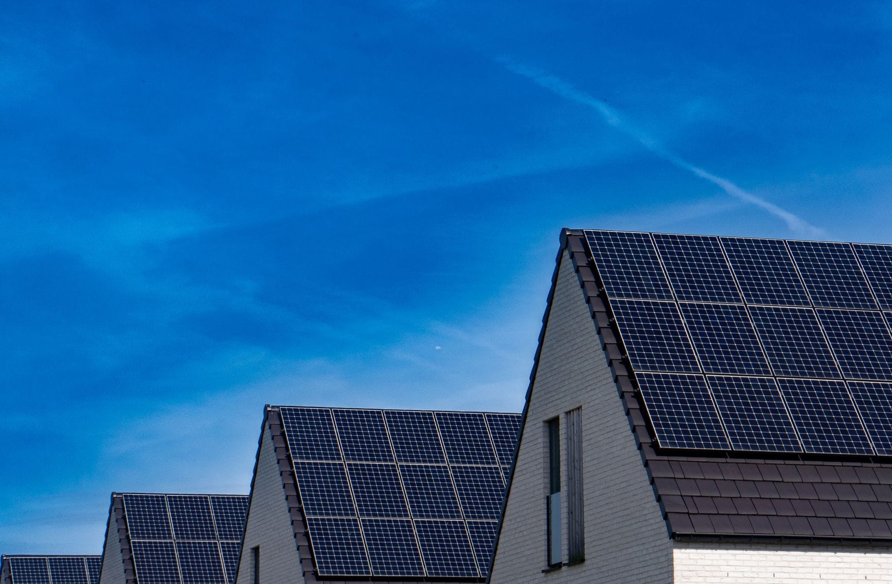 Solar panels on a pitched roof against a blue sky