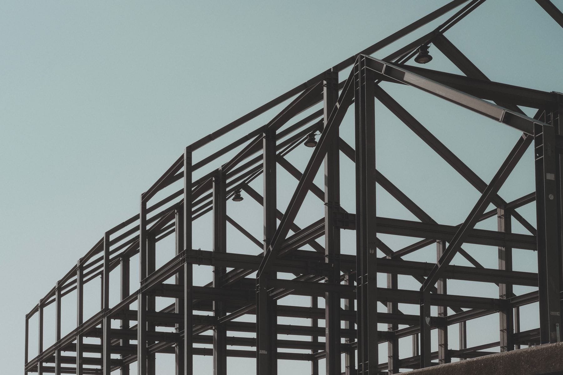 Steel structural frame against a pale sky